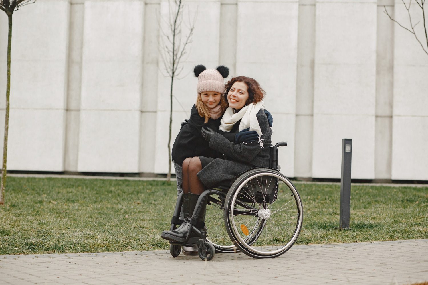 Person in wheelchair with companion outdoors